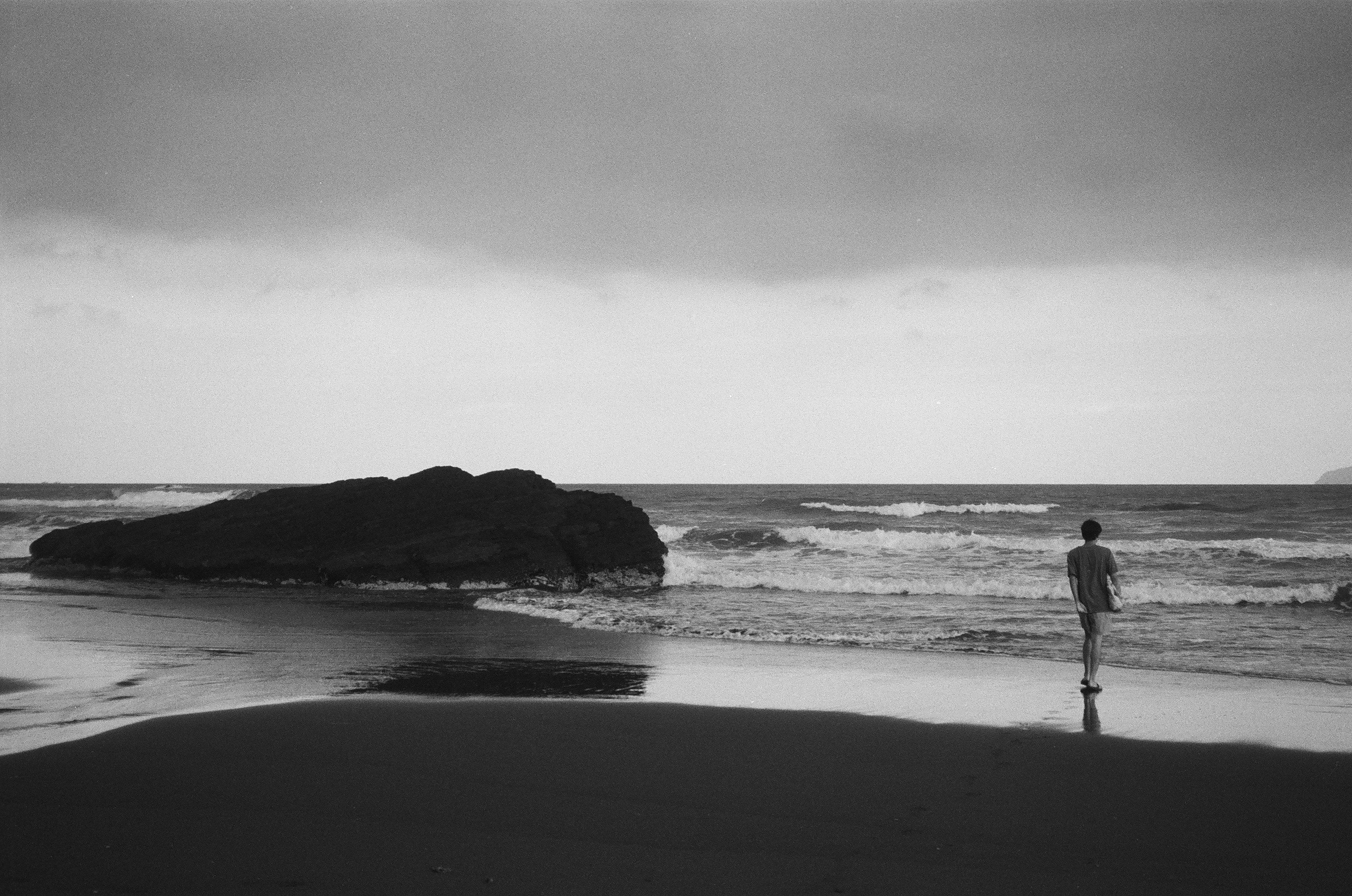 a man standing on a beach next to the ocean